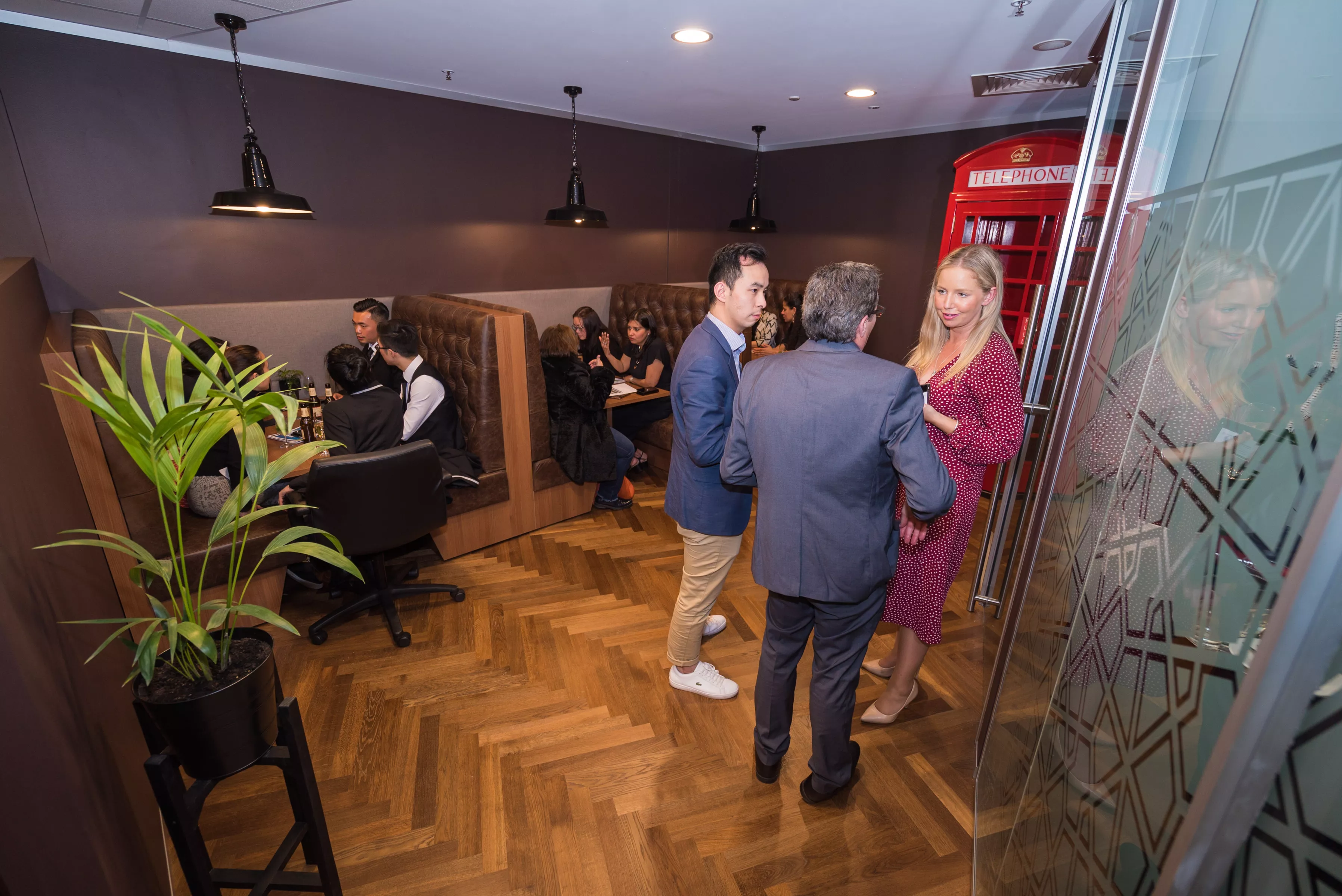 Clients working and conversing in a modern coworking space and booths in Servcorp Southbank, Melbourne