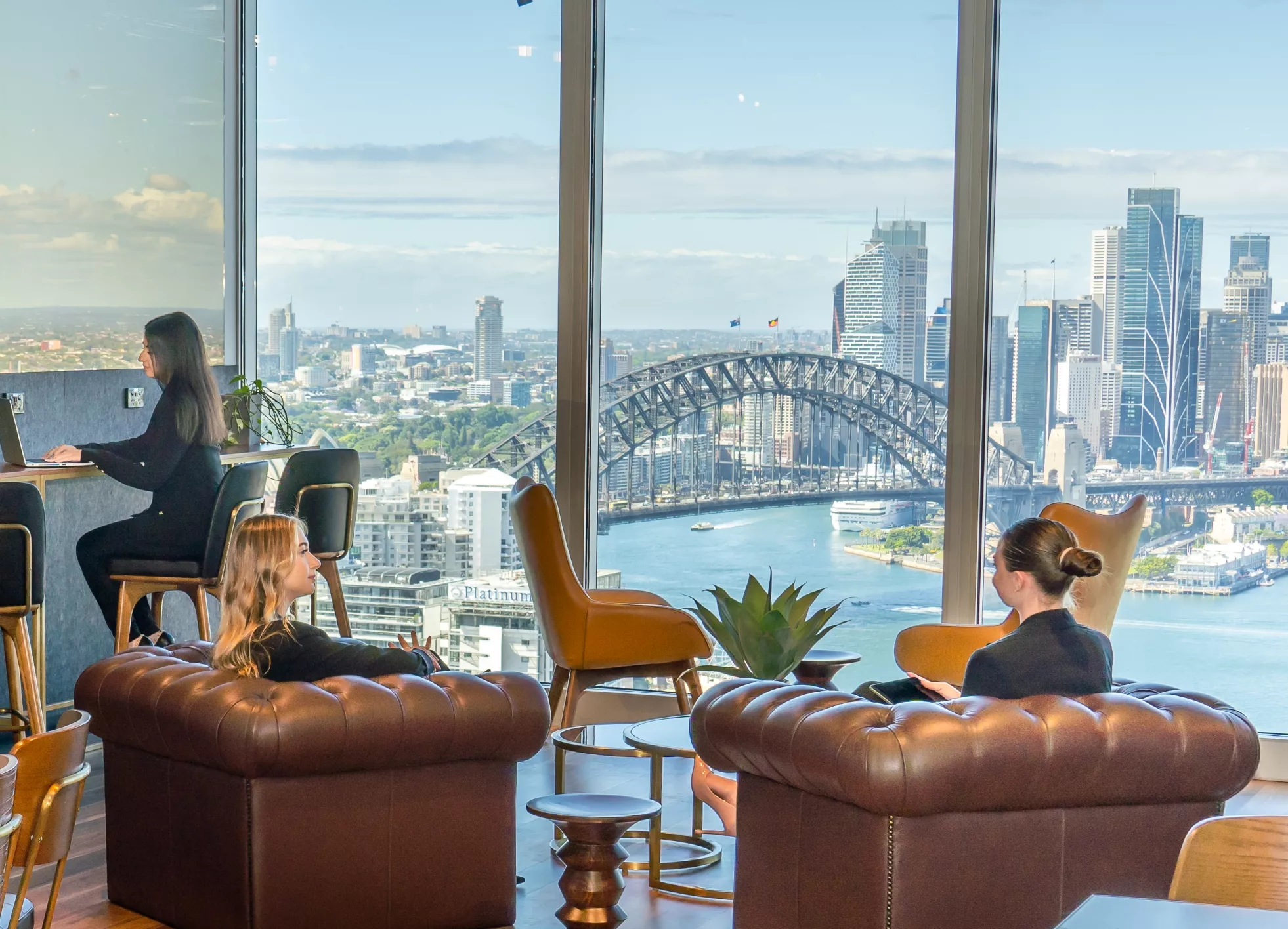 Clients working and enjoying the lounge of a modern coworking space with an epic view within Servcorp 100 Mount Street
