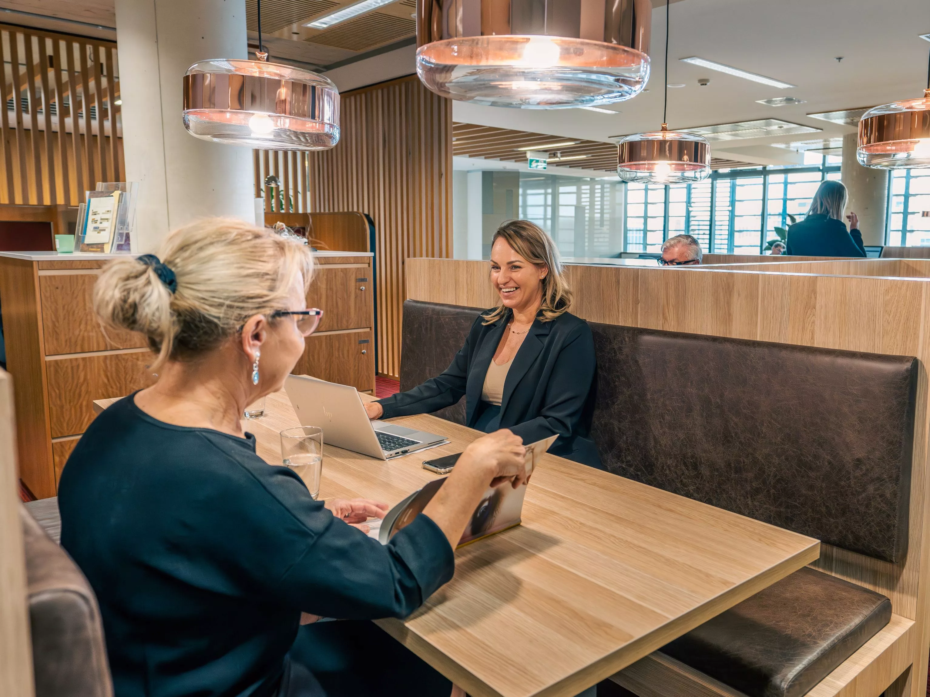 Close up on clients working in a modern coworking space, in Servcorp Nishi Building, Canberra