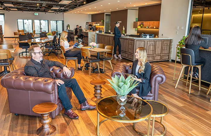 Coworking Space at Qubic Square with people working, modern desks, kitchen area, and a staffed reception.