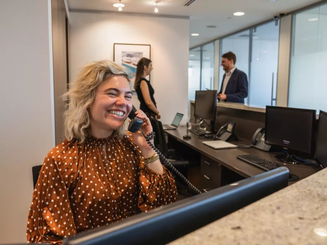 A dedicated receptionist on the phone and another with a client in the modern co-working space of in Servcorp Westfield Tower 2