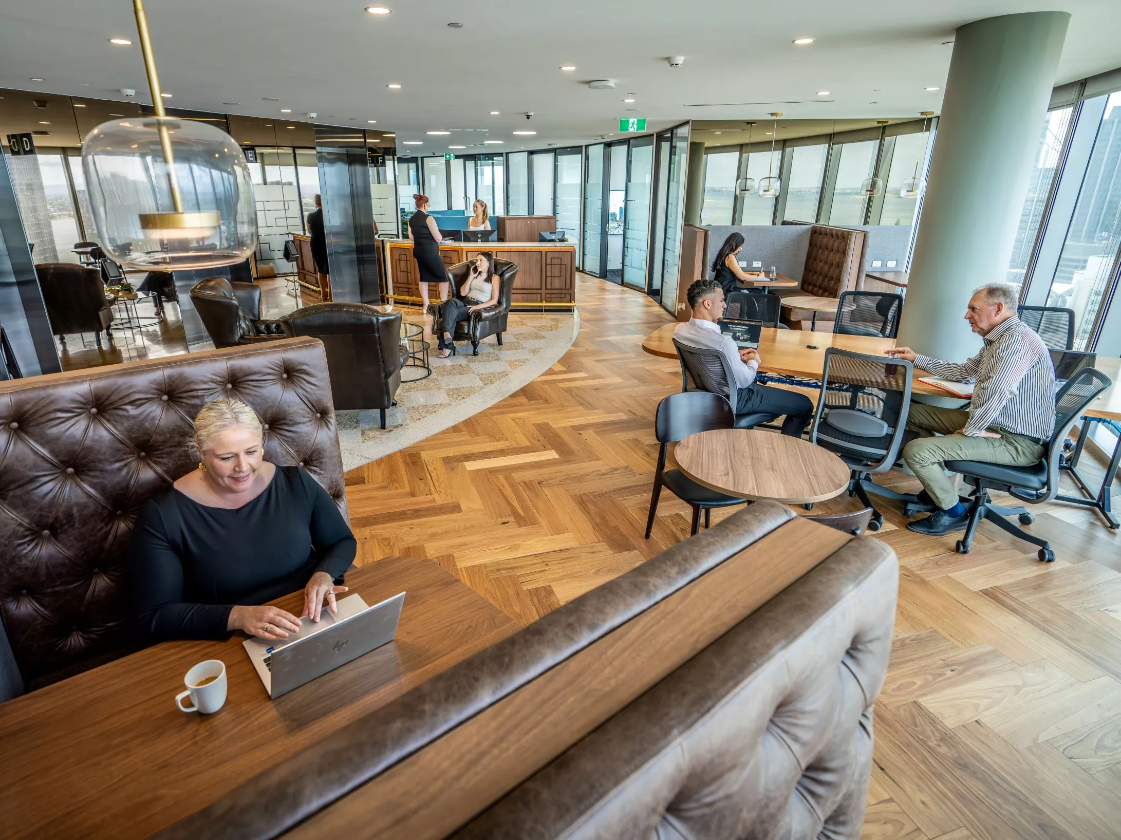 High angle shot of clients working in a modern coworking space on in a hot desk booth, enjoying the lounge in Servcorp Capital Square Tower 3 Perth